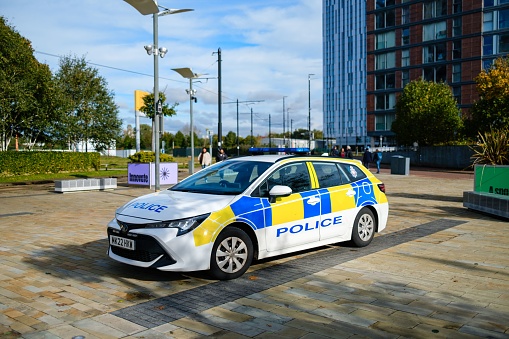 Salford, United Kingdom – October 21, 2023: The Police marked vehicle parked on the pavement, Salford Quays Manchester during the day