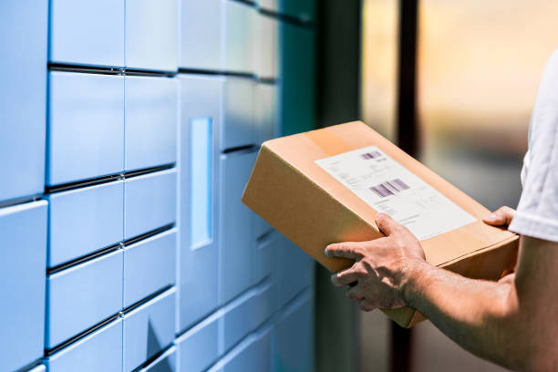 Parcel locker and package delivery service machine. Collect packet at mail storage station at post office. Man holding a box in hand. Blue shipment terminal automat pick up.