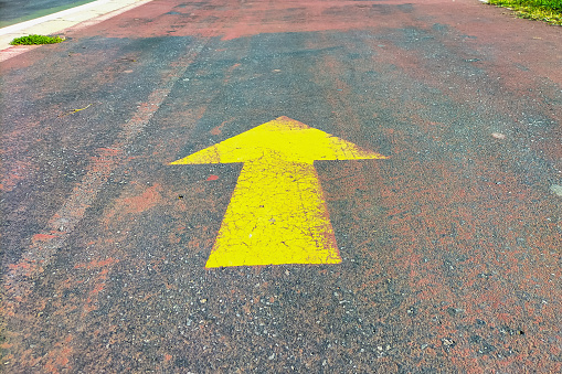 Straight arrow sign on asphalt