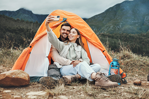 Couple, tent and happy in camping selfie, memory and holiday on web blog, morning and countryside. Man, woman and relax with vacation, social network post and adventure with love, outdoor and freedom