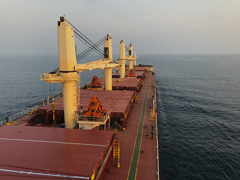 Merchant ship carrying bulk cargo is underway at sea in the morning under low visibility