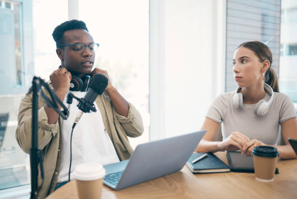 istock Man, podcast team and streaming live or online recording, creative conversation or microphone. Black male person, woman or laptop office for social network, influencer audience or content creating 1772621295