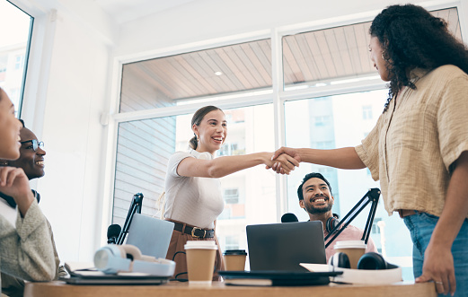 Communication, smile and podcast people shaking hands for hello, teamwork or welcome media guest, influencer or presenter. Thank you handshake, interview and broadcast group happy for radio talk show