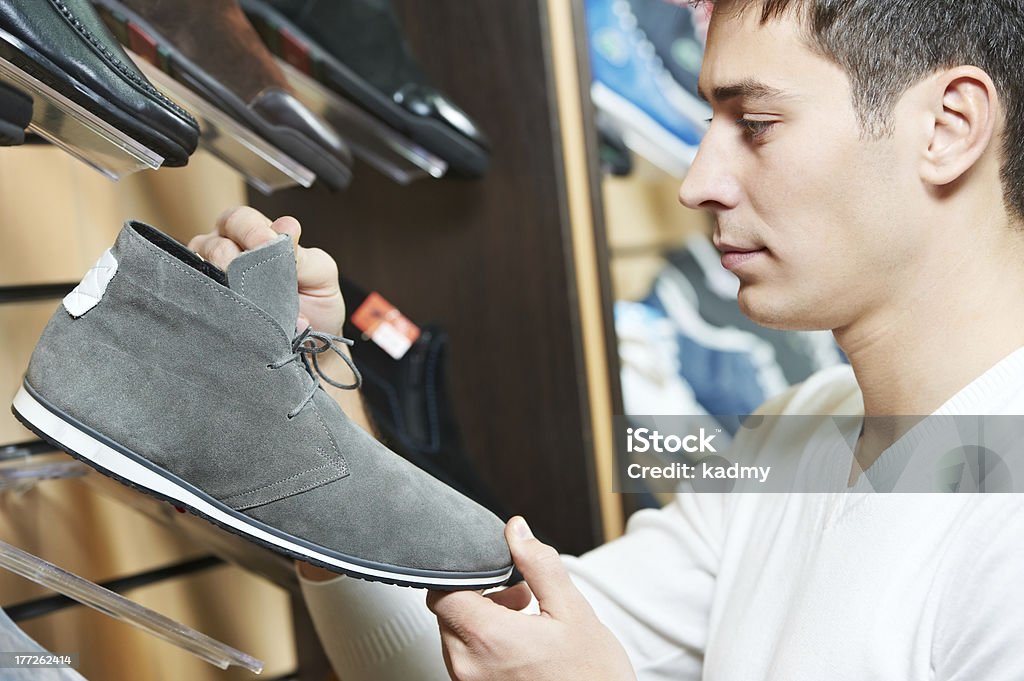Jovem homem escolher calçado em loja de roupas - Foto de stock de Homens royalty-free