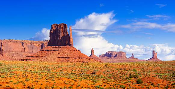 Buttes called Totem Pole in Monument Valley, Arizona, under a partially clouded sky