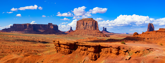 Buttes called Totem Pole in Monument Valley, Arizona, under a partially clouded sky