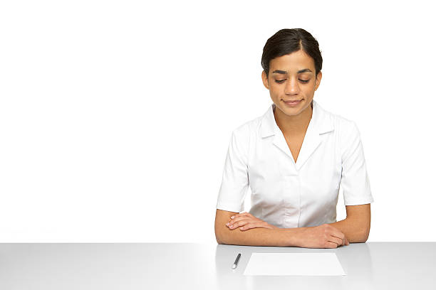 Woman wearing a white lab with pencil and paper stock photo