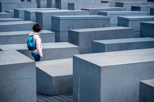 Berlin, Germany - 20 September 2019: Woman standing between stelae of Holocaust Memorial in Berlin, Germany