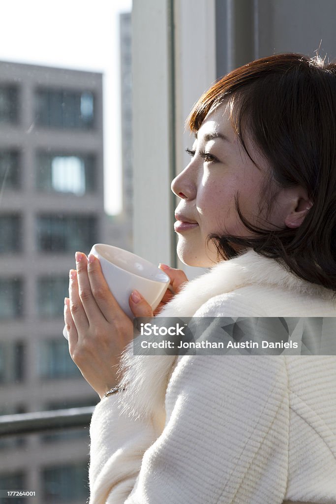 Ragazza giapponese bere il caffè davanti ampia finestra - Foto stock royalty-free di 20-24 anni