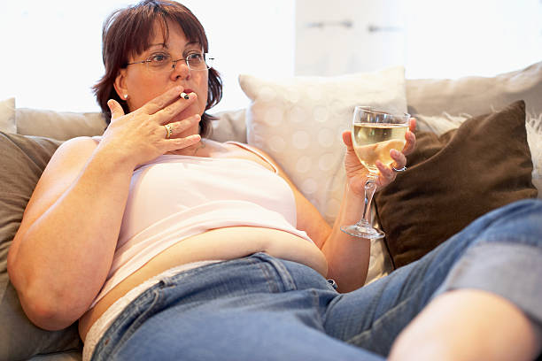 donna sovrappeso rilassante sul divano - abdomen addiction adult alcohol foto e immagini stock