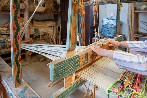 Woman hands on the weaving loom.