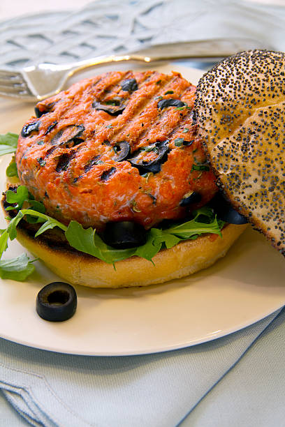 Grilled Salmon Burger with Black Olives stock photo