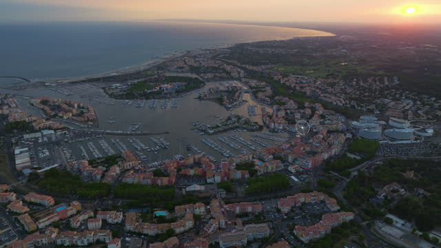 Bird's eye view of the southern coast of France, the sea coast of Agde on the Mediterranean Sea with a view of the island of Loisir and its adjacent marinas at sunset. Tourist vacation spot