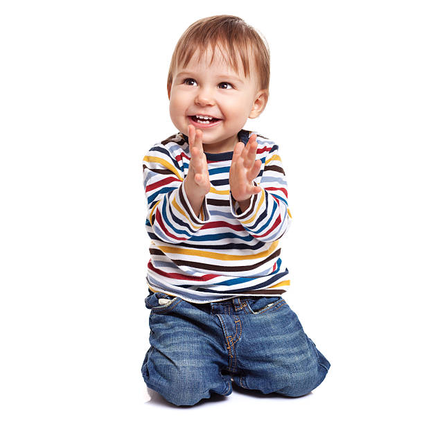 Little boy clapping his hands and smiling stock photo