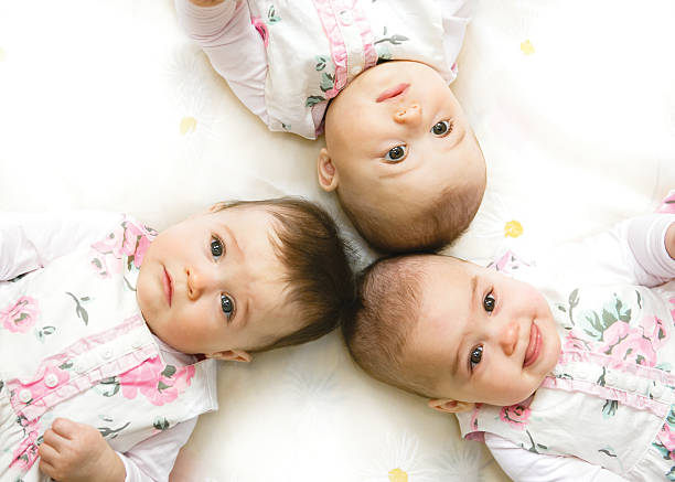 sweet triplet - sibling baby three people baby girls stock-fotos und bilder