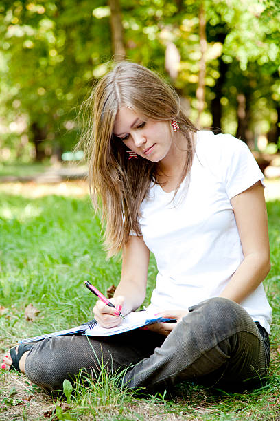 istock Blonde girl doing homework at the park. 177268028