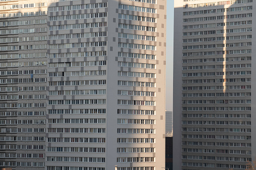 A high-rise apartment building with terraces on a gray sky background. Copy the space