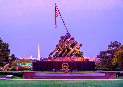 Washington DC, USA - August 30, 2023: The Marine Corps War Memorial with the Capitol and Washington Monument in the background at sunset.