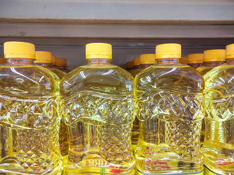 Rows of bottled cooking oil, on the shelves of minimarkets