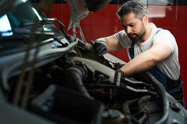 Experienced auto mechanic repairing his client car stock photo