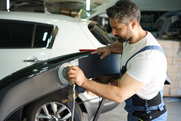 istock Skilled worker polishing vehicle bumper with buffer in his garage 1772689296