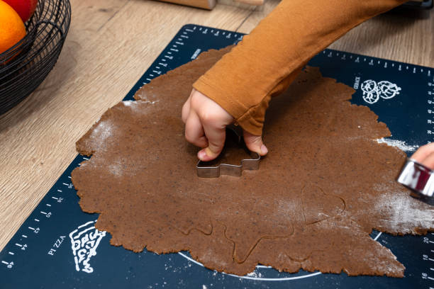 istock A child cutting out various shapes of gingerbread from raw dough using shapes. 1772691045