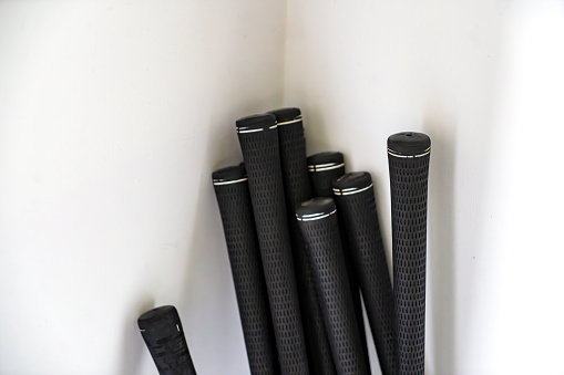 Grips of a golf club set ready for cleaning in a kitchen.