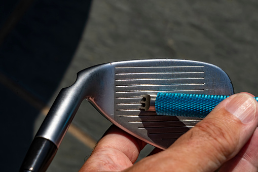Pitching Wedge Golf club being regrooved.