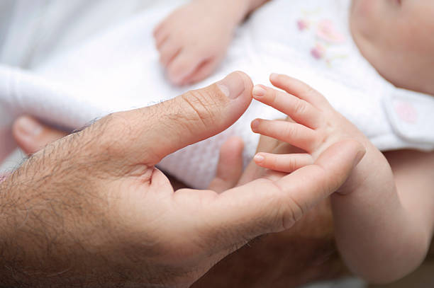 Dad holding baby girl&#180;s hand stock photo