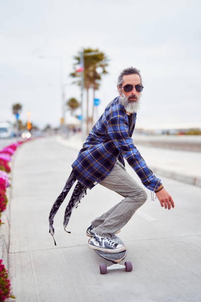istock mature man white beard skateboarding on the street 1772706972