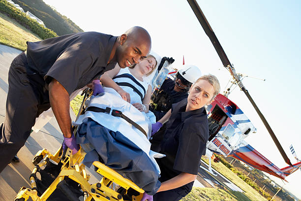 Emergency medical service team is rescuing Asian young man The emergency response team is trying to administer first aid to an Asian man who has had an accident on the side of the road.