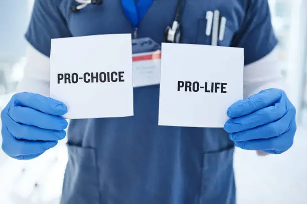 Life, choice and doctor with paper in hands for abortion, human rights or decision in clinic. Nurse, poster and vote for women with option for family planning in hospital or medical contraception