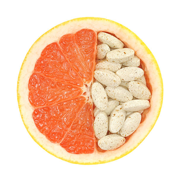 Close-up of a grapefruit halfway filled with pills stock photo