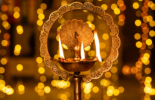 Diya lamp stand in Diwali illuminated light in background