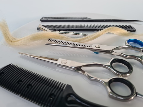 Hairdresser's scissors with comb and strand of blonde hair concept