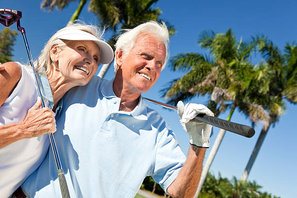 happy senior mann & frau paar spielen golf - senior adult healthy lifestyle athleticism lifestyles stock-fotos und bilder
