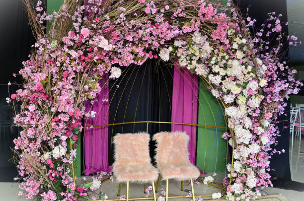 istock Photo backdrop with artificial cherry blossoms and dry branches and pink plush chairs 1772745309