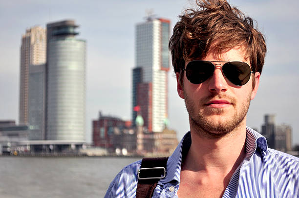 Portrait of a handsome young man on a background of the skyline in Rotterdam, Netherlands.
