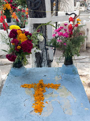 A grave decorated with a simple cross of Marigolds and other flowers, on November second, during the annual ceremony of the \