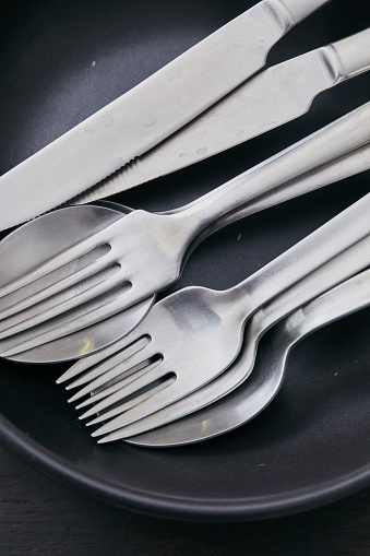 Silver cooking cutlery props on black background, representing luxury lifestyle, art of cooking and food culture