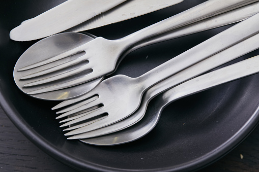 Silver cooking cutlery props on black background, representing luxury lifestyle, art of cooking and food culture