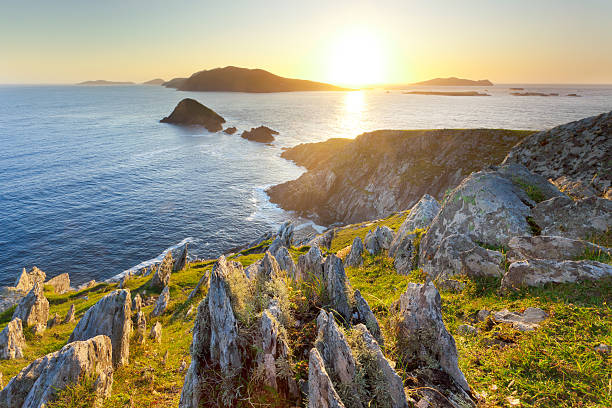 sunset over islands on irish west coast "backlit seascape taken from cliffs towards blasket islands on dingle peninsula, ireland" dingle bay stock pictures, royalty-free photos & images