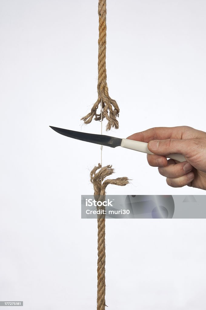 Cutting a rope cutting a rope with a knife Business Stock Photo