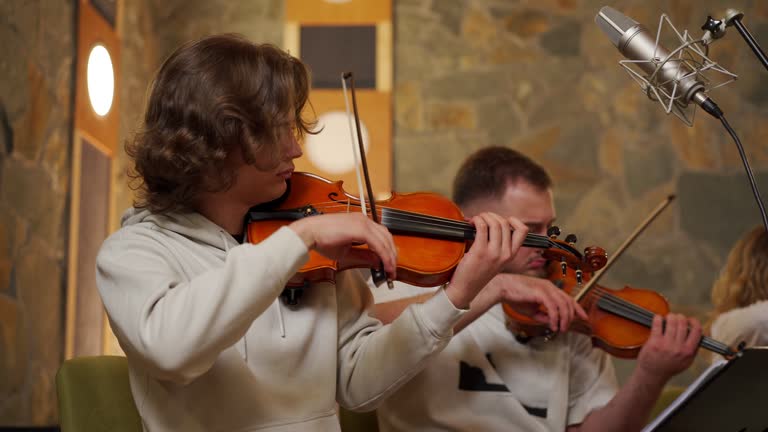 Group of young adult music students rehearsing in music studio