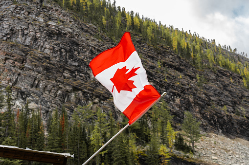 Canadain flag flying in the wind atop the tea house at Lake Louise, Banff.