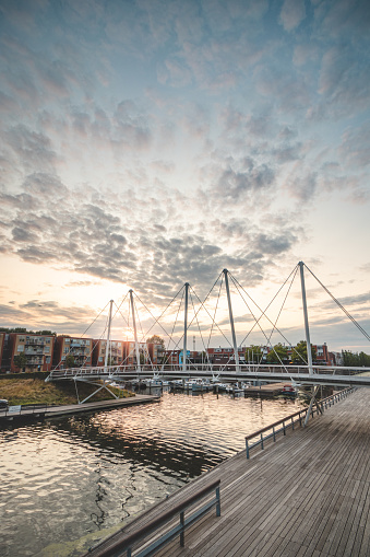 Pedestrian and bicycle bridge over the harbour in the centre of Almere during sunset. Dutch modern and utilitarian construction.