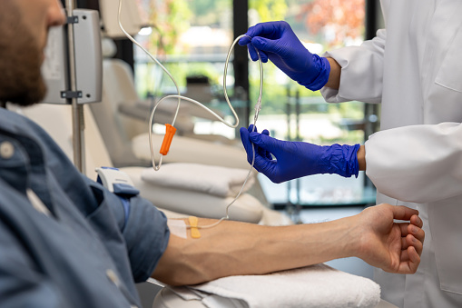 Healthcare and medicine. Patient man receiving infusion drip in hospital or beauty salon.