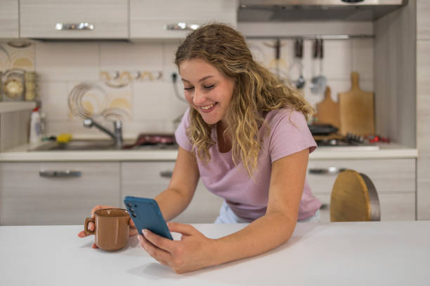 istock Girl surfing the net while drinking a coffee on the counter in the kitchen 1772784134