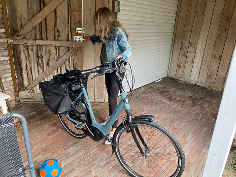 Woaman arriving home on bicycle after her sport exercise