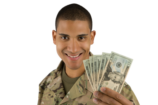 A happy soldier holds money in his hands